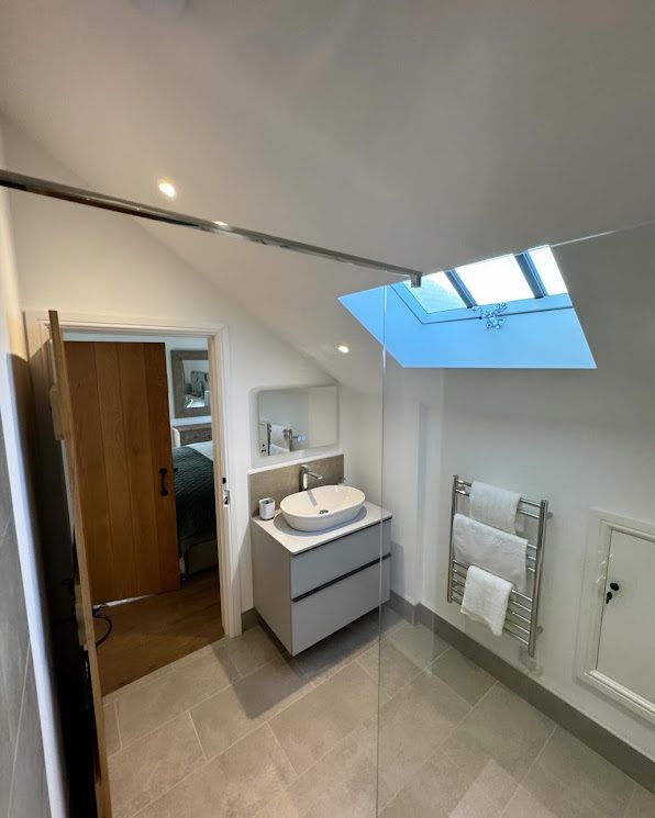 Renovated bathroom with vanity unit and skylight