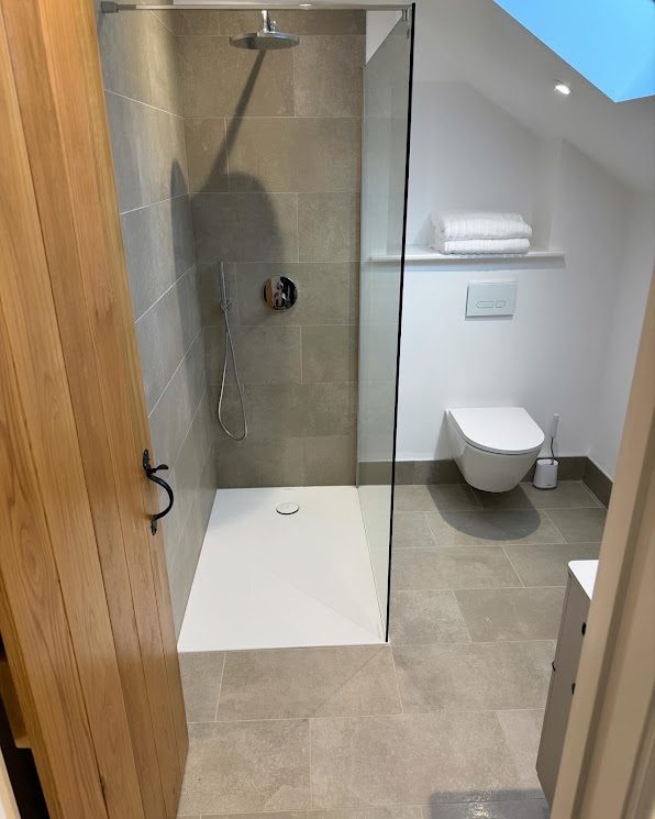 Finished loft bathroom with walk-in shower and oak door