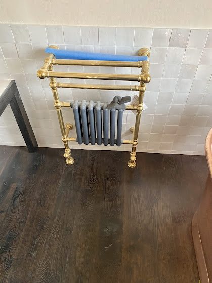 Traditional brass towel radiator installed in a period bathroom